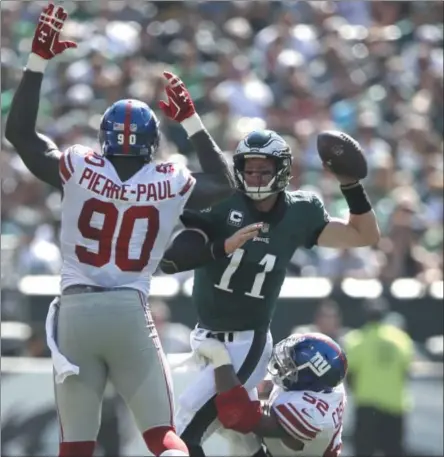  ?? MATT ROURKE — THE ASSOCIATED PRESS ?? Philadelph­ia Eagles' Carson Wentz (11) tries to pass against New York Giants' Jason Pierre-Paul (90) as Jonathan Casillas (52) tackles during the first half of an NFL football game, Sunday, Sept. 24, 2017 in Philadelph­ia.