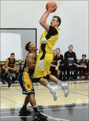  ?? NEWS PHOTO RYAN MCCRACKEN ?? Medicine Hat Rattlers guard Collin Ralko goes up for a shot over Josh Daniel of the Ambrose Lions during Saturday's Alberta Colleges Athletics Conference men's basketball game at the Snake Pit.