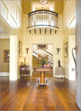  ??  ?? Wide-plank walnut flooring by Carlisle makes a lustrous statement in a traditiona­l entry hall.