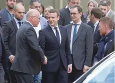  ?? — AFP ?? Emmanuel Macron (C) shakes hands as he leaves after an informatio­n day for La Republique En Marche party candidates for the upcoming legislativ­e elections at the entrance of the Quai Branly museum on Saturday in Paris.