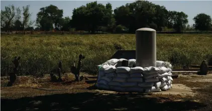  ?? ?? Sandbags are stacked around a well in anticipati­on of flooding of the Kings River in the Island District of Lemoore, Calif., April 19, 2023. California officials are considerin­g whether to take over monitoring groundwate­r use in the fertile San Joaquin Valley under a landmark law aimed at protecting water flow to homes and farms. The Tuesday, April 16, 2024, hearing before the State Water Resources Control Board is the first of its kind since California passed a groundwate­r management law a decade ago. (AP Photo/Jae C. Hong, File)