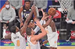  ?? POOL PHOTO/USA TODAY SPORTS ?? Knicks guard RJ Barrett, middle, drives for a layup against Magic forward Dwayne Bacon (8) and center Nikola Vucevic (9) during the first half at Madison Square Garden on Monday.