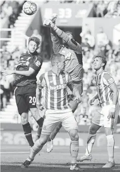  ??  ?? Stoke City’s English goalkeeper Jack Butland (left) punches clear, under pressure from Liverpool’s English midfielder Adam Lallana during the English Premier League football match between Stoke City and Liverpool at the Britannia Stadium in...