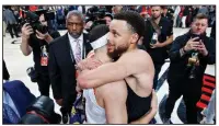  ?? AP/CRAIG MITCHELL DYER ?? Golden State guard Steph Curry (right) hugs his brother, Portland guard Seth Curry, on the court Monday night after the Warriors defeated the Trail Blazers 119-117 in overtime in Portland, Ore.