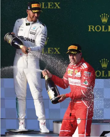  ?? — AFP ?? Ferrari’s Sebastian Vettel (right) celebrates with Lewis Hamilton of Mercedes after winning the Australian Grand Prix in Melbourne on Sunday. Hamilton came second ahead of team mate Valtteri Bottas.