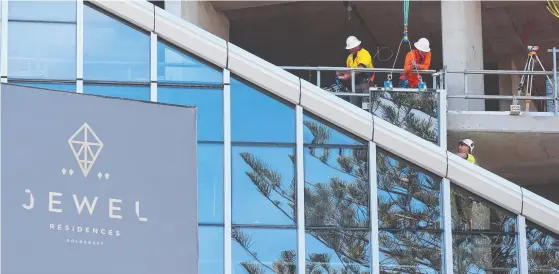  ?? Picture: MIKE BATTERHAM ?? Workmen at the Jewel developmen­t at Broadbeach installing some of the 16,000 glass panels that will cover the building.