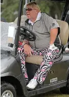  ??  ?? Riding into a storm: John Daly sits in his golf buggy