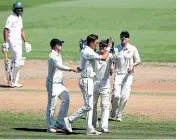  ??  ?? Shane Bond is congratula­ted after taking the wicket of Soumya Sarkarin Hamilton yesterday.