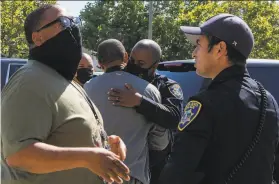  ?? Nina Riggio / The Chronicle ?? Oakland Police Chief LeRonne Armstrong embraces Doral Myles, a violence interrupte­r for Youth Alive in Oakland, after a fatal shooting in West Oakland on Friday.