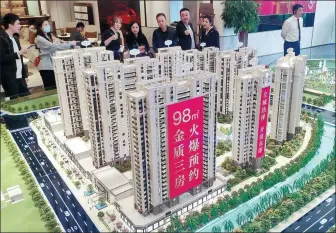  ?? LYU MING / CHINA NEWS SERVICE ?? Potential homebuyers look at a property model in Fuzhou, capital of East China’s Fujian province.