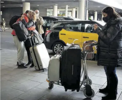  ?? Elisenda Pons ?? Uns passatgers se saluden a l’arribar a l’aeroport de Barcelona.