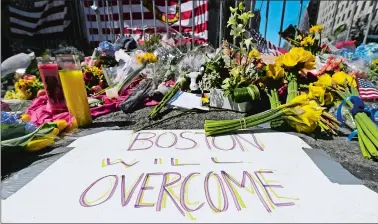  ?? CHARLES KRUPA/AP PHOTO, FILE ?? In this April 17, 2013, photograph, flowers and signs adorn a barrier, two days after two explosions killed three and injured hundreds, at Boylston Street near the of finish line of the Boston Marathon at a makeshift memorial for victims and survivors of the bombing. A federal appeals court has overturned the death sentence of Dzhokhar Tsarnaev in the 2013 Boston Marathon bombing, saying the judge who oversaw the case didn’t adequately screen jurors for potential biases.