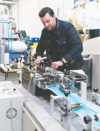  ?? RICHARD LAM/PNG ?? Jason Zanatta of Novo Textiles sets up a two-tonne mask-making machine that was delivered to his Coquitlam factory on Monday.