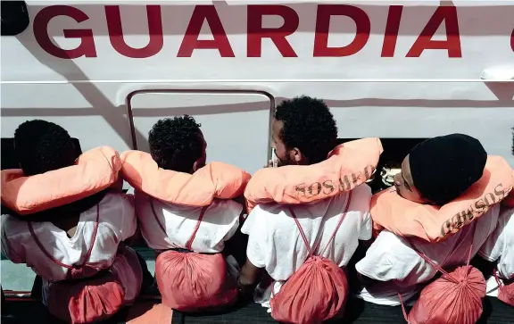  ??  ?? Trasbordo Alcuni dei migranti che erano a bordo della nave Aquarius vengono spostati su uno dei mezzi della Guardia Costiera italiana: il loro viaggio terminerà a Valencia