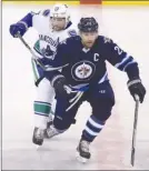  ?? The Canadian Press ?? Vancouver Canucks defenceman Alex Edler collides with Winnipeg Jets captain Blake Wheeler (26) during first-period NHL action in Winnipeg on Sunday.