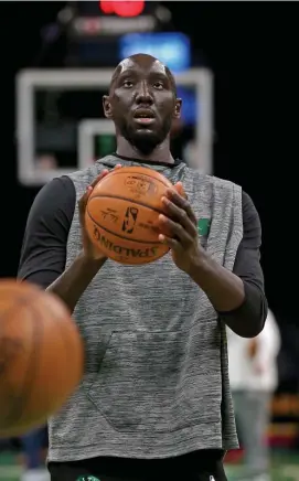  ?? STuART cAHILL pHoTos / HeRALd sTAFF FILe ?? ‘BIG FOR MY SIZE’: Celtics center Tacko Fall warms up last season before a game against the Sixers in February. Below, Fall defends Pistons’ Sekou Doumbouya in December 2019.