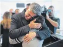  ??  ?? Ryan Pourjam, 13, son of crash victim Mansour Pourjam, is embraced by family friend Mahmoud Rastgou, after a ceremony at Carleton University.