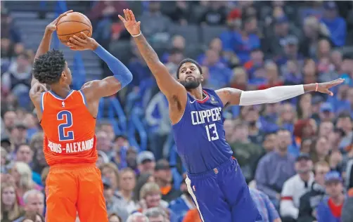  ??  ?? ABOVE: Clippers forward Paul George, right, defends a shot by the Thunder’s Shai Gilgeous-Alexander on Sunday in Oklahoma City. The Clippers play the Lakers in a primetime matchup on Christmas Day.