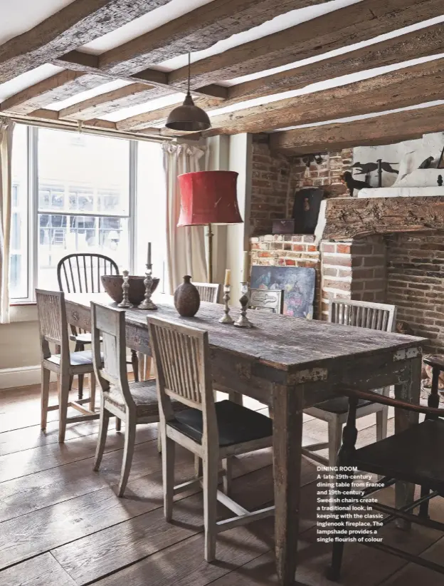  ??  ?? DINING ROOM A late-19th-century dining table from France and 19th-century Swedish chairs create a traditiona­l look, in keeping with the classic inglenook fireplace. The lampshade provides a single flourish of colour