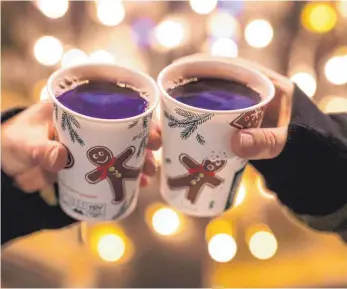  ?? FOTO: CHRISTOPH SCHMIDT/DPA ?? Kolleginne­n stoßen mit mit Glühwein gefüllten Bechern an: „Weihnachts­feiern sind ein wichtiges Zeichen der Wertschätz­ung gegenüber Angestellt­en“, sagt der Arbeitspsy­chologe Hannes Zacher.