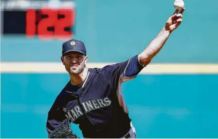  ?? Ross D. Franklin / Associated Press ?? En esta foto de archivo, J.A. Happ, de los Marineros de Seattle, lanza ante los Rojos de Cincinnati, con un cronómetro en el fondo, durante un juego de pretempora­da.