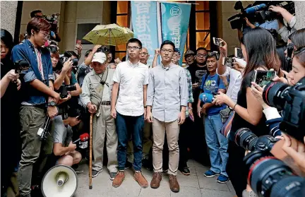  ?? PHOTO: REUTERS ?? Pro-democracy activists Joshua Wong, centre left, and Nathan Law walk out of the Court of Final Appeal after being granted bail in Hong Kong yesterday.