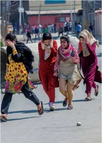  ?? AP ?? Girls run for cover as Kashmiri youth clash with paramilita­ry soldiers during a protest in Srinagar on Sunday. —