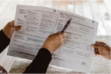  ?? Michael Gonzalez/Associated Press 2023 ?? Children’s Defense Fund Program Director Graciela Camarena assists Lucia Salazar with filling out Medicaid and SNAP applicatio­n forms for her family in Pharr, Texas.