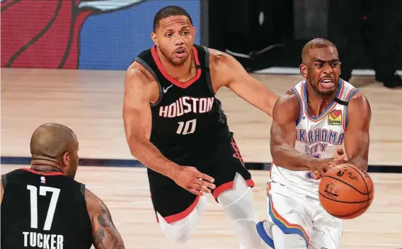  ?? Phots by Kim Klement / Getty Images ?? The Thunder’s Chris Paul, right, gets past Eric Gordon and P.J. Tucker is in no position to help as the Rockets suffer a defensive breakdown Monday.