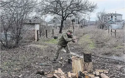  ?? BRENDAN HOFFMAN GETTY IMAGES ?? Anatoliy, a Ukrainian soldier known as “Bossman,” chops wood on Wednesday in Ukraine.