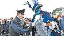  ??  ?? Agente de la policía italiana revisa a un asistente al Carnaval de Venecia que fue cancelado ayer para evitar más contagios del Covid-19.