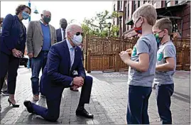  ?? CAROLYN KASTER / AP ?? Democratic presidenti­al candidate former Vice President Joe Biden talks to two boys as he leaves the Amazing Grace Bakery & Cafe in Duluth, Minn., on Friday, with the Mayor of Duluth Emily Larson, left, and Minnesota Mayor Tim Walz, center.