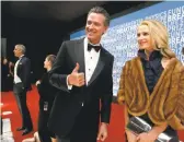  ??  ?? Lt. Gov. Gavin Newsom gives a thumbs-up while walking on the red carpet with this wife, Jennifer Siebel Newsom, before the Breakthrou­gh Prizes at Moffett Airfield.