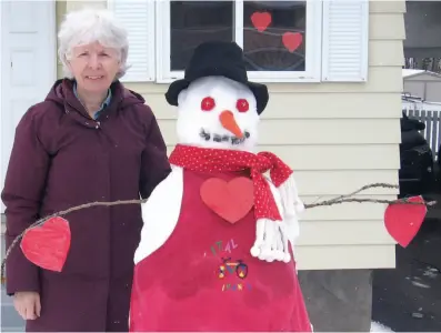 ?? CITIZEN STAFF PHOTO ?? Myrna Lemky poses with Snowgranny, the snowwoman she made Monday in her Baker Street yard to put smiles on the faces of her two granddaugh­ters who she can’t hug right now due to the COVID19 pandemic.