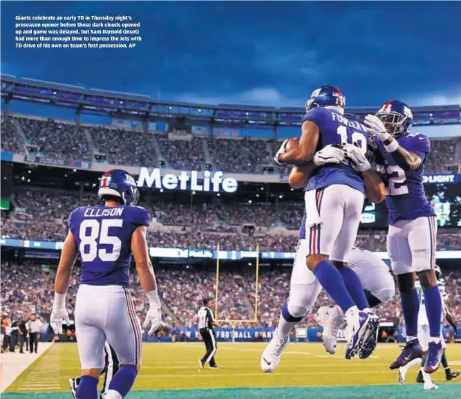  ??  ?? Giants celebrate an early TD in Thursday night’s preseason opener before those dark clouds opened up and game was delayed, but Sam Darnold (inset) had more than enough time to impress the Jets with TD drive of his own on team’s first possession. AP