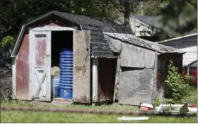  ?? JOHN MINCHILLO — THE ASSOCIATED PRESS ?? A shed stands in a backyard where police say a man with mental health problems kidnapped a neighbor and kept her trapped in a small grave-like pit in the shed Wednesday in Blancheste­r. Ohio. Police in Blancheste­r, about 40 miles northeast of...