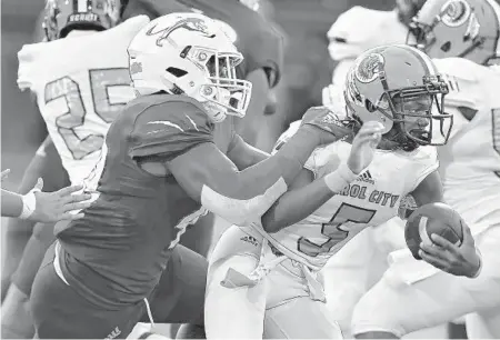  ?? MICHAEL LAUGHLIN/SUN SENTINEL ?? Chaminade Madonna’s Jamaal Johnson tackles Carol City’s Keyone Jenkins during the first half of their game Friday night in Hollywood.