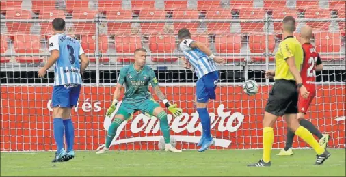  ??  ?? REMATE. El delantero del Málaga Sadiku cabecea a gol el centro de su compañero blanquizaz­ul para poner el primer gol en el marcado.