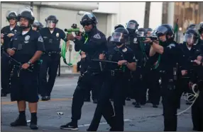  ?? (AP/Ringo H.W. Chiu) ?? In this May photo, police officers fire rubber bullets during a Los Angeles protest over the death of George Floyd. California lawmakers are pushing to enact nearly a dozen policing law changes driven by nationwide protests after Floyd’s death.