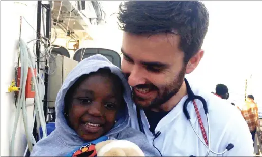  ??  ?? Dr Conor Kenny with a little boy on board the ‘ Aquarius’ who had just been rescued in the Mediterran­ean Sea. Dr Conor Kenny.