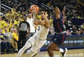  ?? JOSE JUAREZ — THE ASSOCIATED PRESS ?? Michigan’s Jaelin Llewellyn, left, drives to the basket as he is guarded by Jackson State’s Chase Adams in the second half of the Wolverines’ 78-68home victory on Wednesday.
