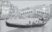  ?? BLOOMBERG ?? ■
Tourists ride a gondola near the Rialto Bridge in Venice.