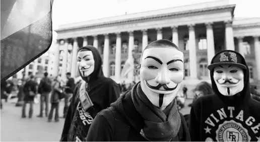  ?? KENZO TRIBOUILLA­RD / AFP / Gett y Images ?? Guy Fawkes masks are often worn by Anonymous supporters. Top, Communicat­ions Security Establishm­ent headquarte­rs.