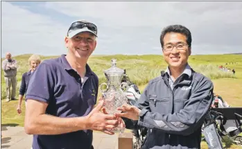  ?? Photograph­s: John McFadyen. ?? Mr YC Kim of CS Wind UK presents the Campbeltow­n Open trophy to an understand­ably delighted first-time winner, George MacMillan.