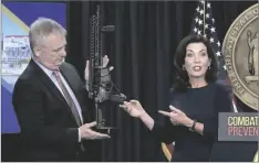  ?? OFFICE OF THE GOVERNOR OF NEW YORK VIA AP ?? In this image taken from video, Kevin Bruen, Superinten­dent of the New York State Police, holds a firearm as New York Gov. Kathy Hochul speaks during a news conference, on Wednesday in New York.