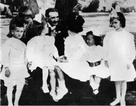  ??  ?? Clockwise from right: Frank Baum with children in 1914; in a scene from the iconic film, Dorothy and her friends meet the Wizard; the 1902 musical adaption.