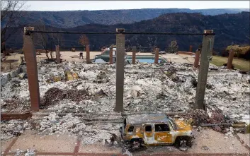  ?? AP Photo/NoAh Berger ?? A vehicle rests in front of a home leveled by the Camp Fire in Paradise, Calif., on Monday.