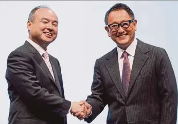  ?? EPA PIC ?? SoftBank Corp. chief executive officer Masayoshi Son (left) and Toyota Motor Corp president Akio Toyoda at a joint announceme­nt of their new venture to develop mobility services, Monet, in Tokyo yesterday.