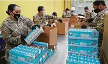  ?? Melissa Phillip / Staff photograph­er ?? Army National Guard Spec. Katty Gracia, left, and Pfc. Jemal Watler, right, and others pack boxes at the Houston Food Bank.