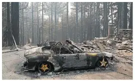  ?? MARCIO JOSE SANCHEZ/AP ?? A burned vehicle is seen Friday near a fire-damaged home in Bonny Doon, California.